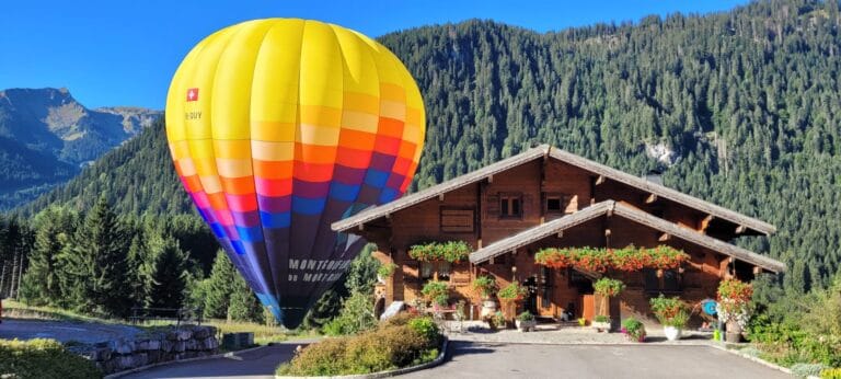 Vue de notre montgolfière se trouvant derrière un chalet en pleine montagne